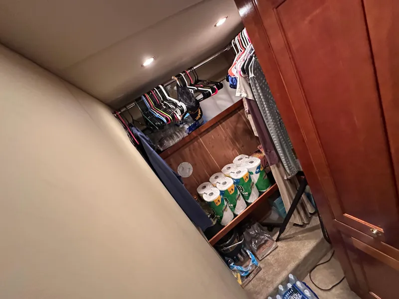 Slide: The Image of Closet storage inside 2005 Cruisers Yachts 540 Express, featuring clothes and household supplies. - 29
