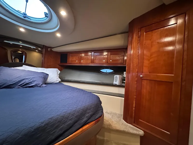Slide: The Image of Luxurious 2005 Cruisers Yachts 540 Express cabin with wood cabinetry and cozy bedding. - 31