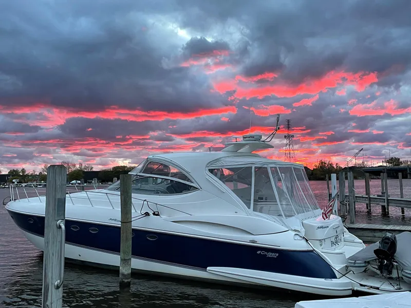 Slide: The Image of 2005 Cruisers Yachts 540 Express docked at sunset with vibrant pink clouds. - 43