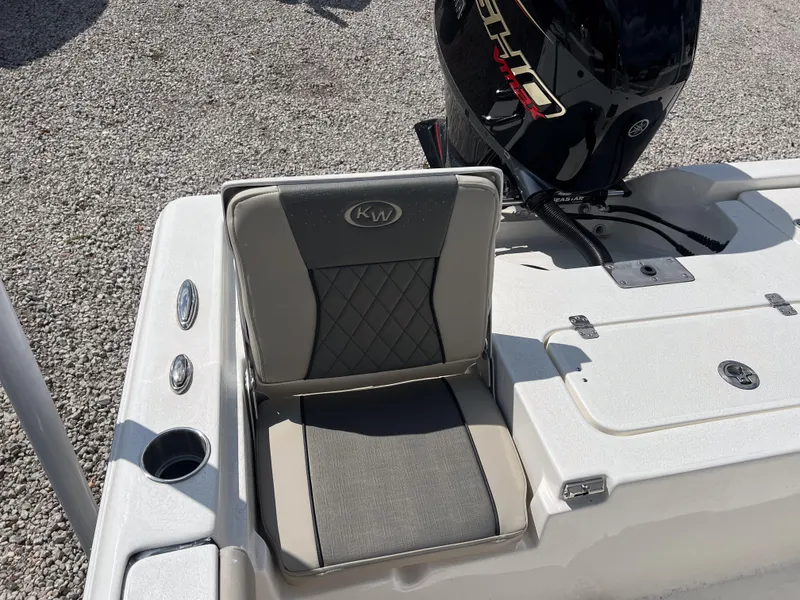 Slide: The Image of Key West 210 Bay Reef 2025 boat seat and motor detail, gravel background. - 11