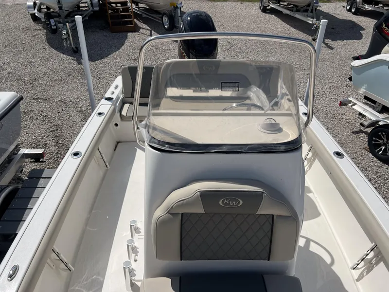 Slide: The Image of 2025 Key West 210 Bay Reef boat interior with console and seating, displayed outdoors. - 15