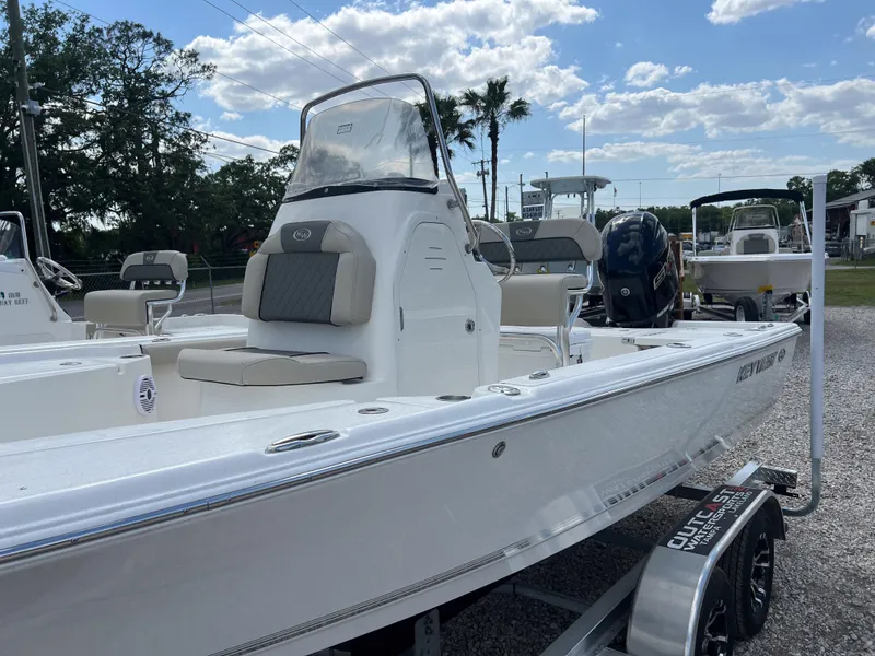 Slide: The Image of 2025 Key West 210 Bay Reef boat on trailer, parked outdoors under a partly cloudy sky. - 3