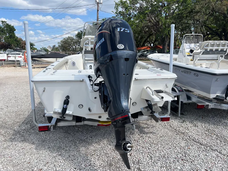 Slide: The Image of 2025 Key West 210 Bay Reef boat with Yamaha 175 engine, parked on gravel. - 4