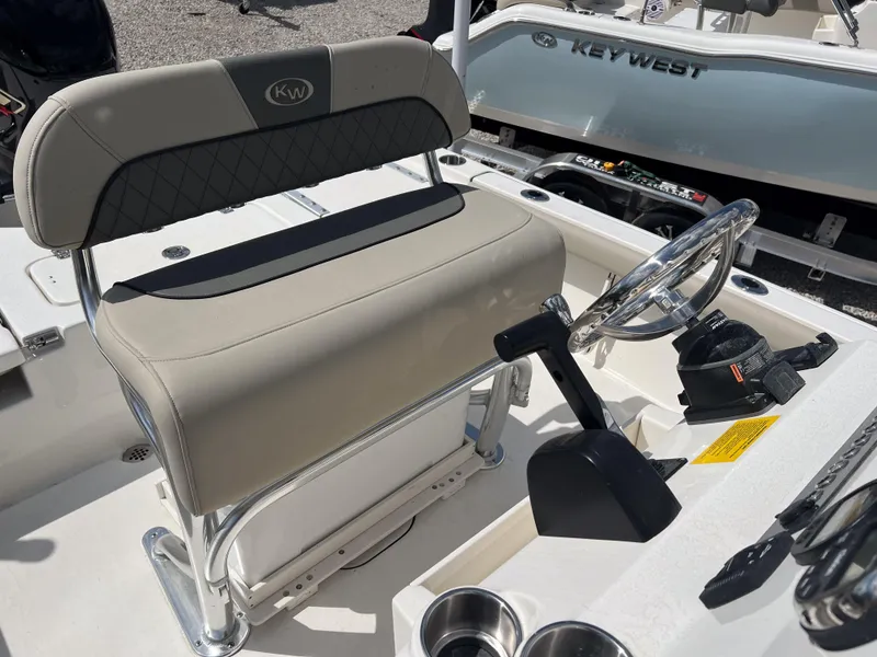 Slide: The Image of 2025 Key West 210 Bay Reef boat interior with steering wheel and seating. - 9