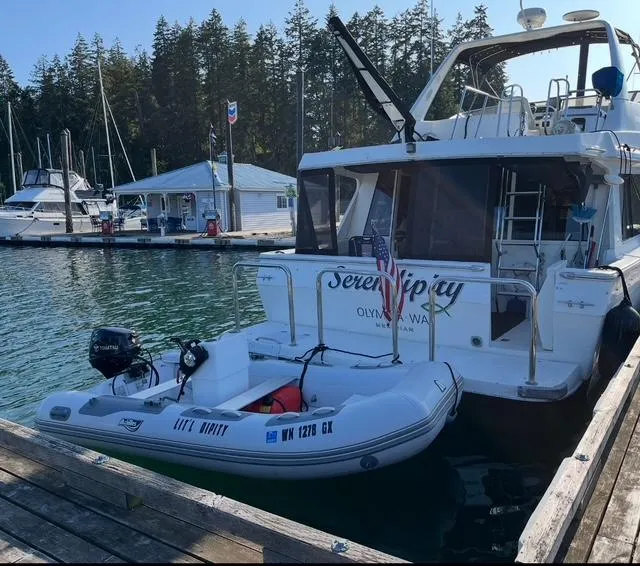 Slide: The Image of 2005 Meridian PILOTHOUSE yacht docked with inflatable boat, serene marina setting. - 2