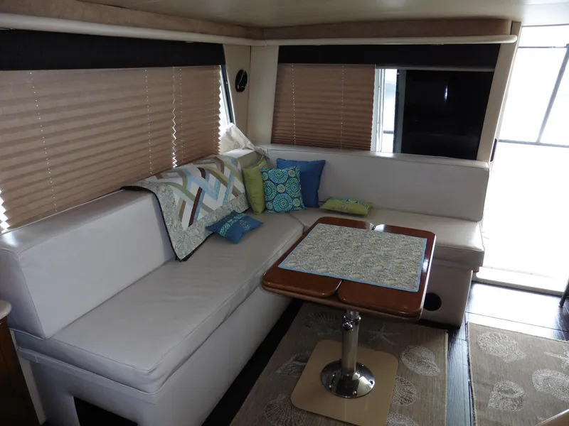 Slide: The Image of 2005 Meridian PILOTHOUSE interior with white seating, decorative pillows, and a wooden table. - 20