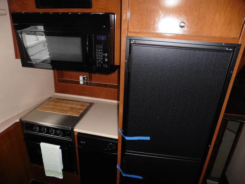 Slide: The Image of 2005 Meridian PILOTHOUSE kitchen with microwave, stove, and refrigerator. - 24
