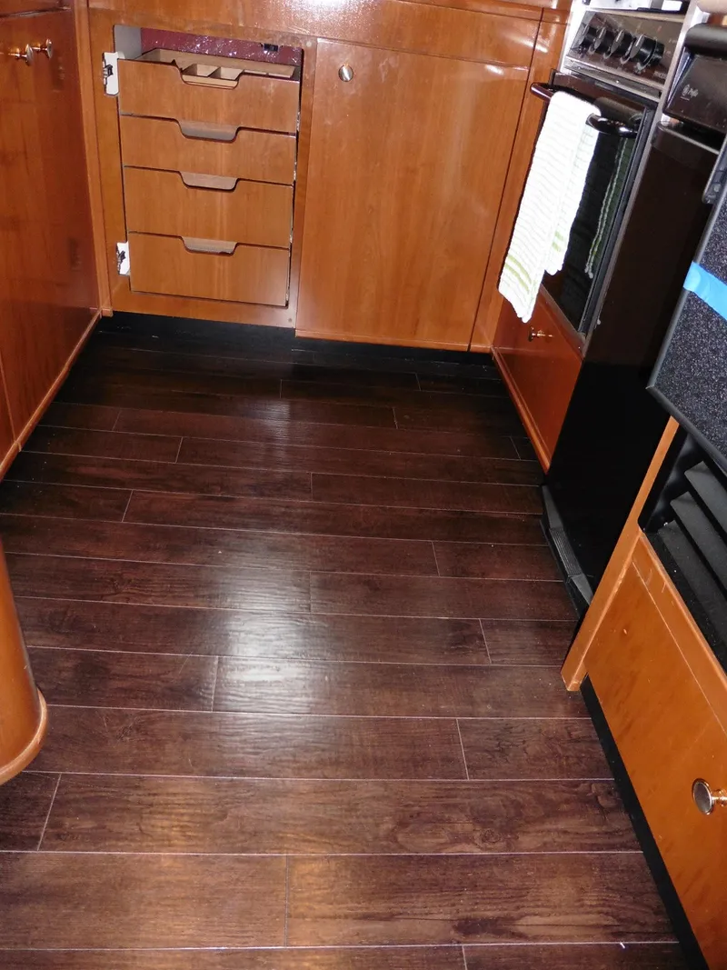 Slide: The Image of 2005 Meridian PILOTHOUSE kitchen with wooden cabinets and dark hardwood flooring. - 25