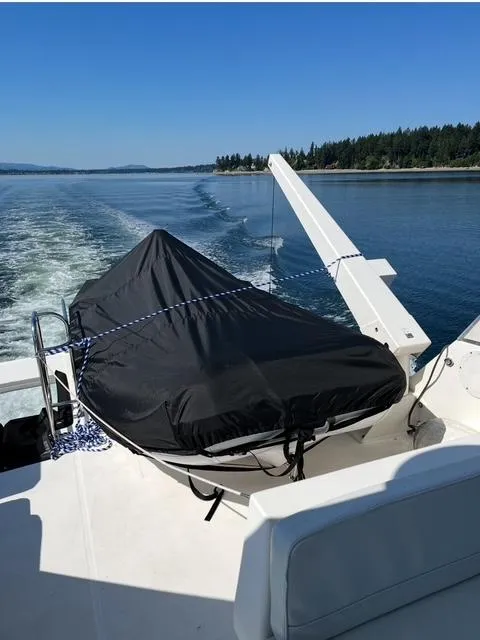 Slide: The Image of 2005 Meridian PILOTHOUSE boat with covered equipment, cruising on a scenic waterway. - 8