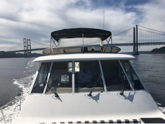 Slide: The Image of 2005 Meridian PILOTHOUSE yacht cruising near a large suspension bridge under a cloudy sky. - 9