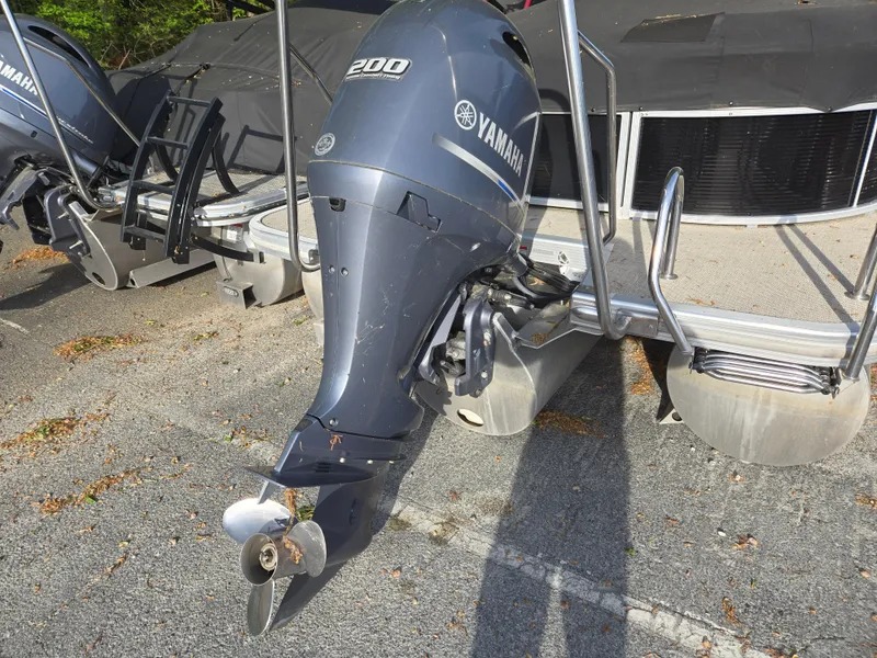 Slide: The Image of 2015 Bennington 24 SSRX30 with Yamaha 200 outboard motor, parked on pavement. - 10