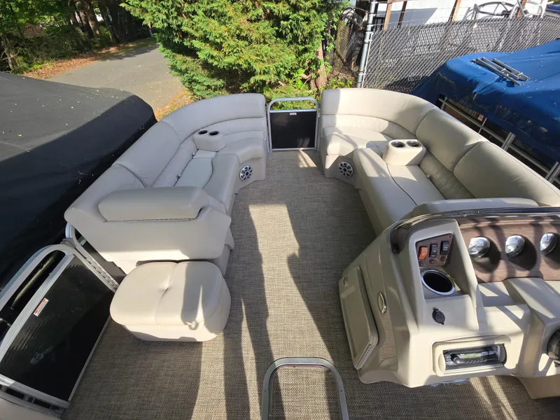 Slide: The Image of 2015 Bennington 24 SSRX30 pontoon boat interior with beige seating and control panel. - 16