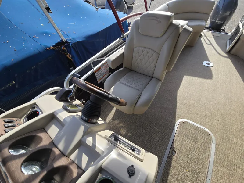 Slide: The Image of 2015 Bennington 24 SSRX30 boat interior with steering wheel and seating area. - 17