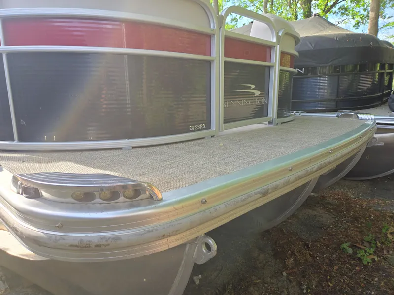 Slide: The Image of 2015 Bennington 24 SSRX30 pontoon boat, side view, docked outdoors. - 2