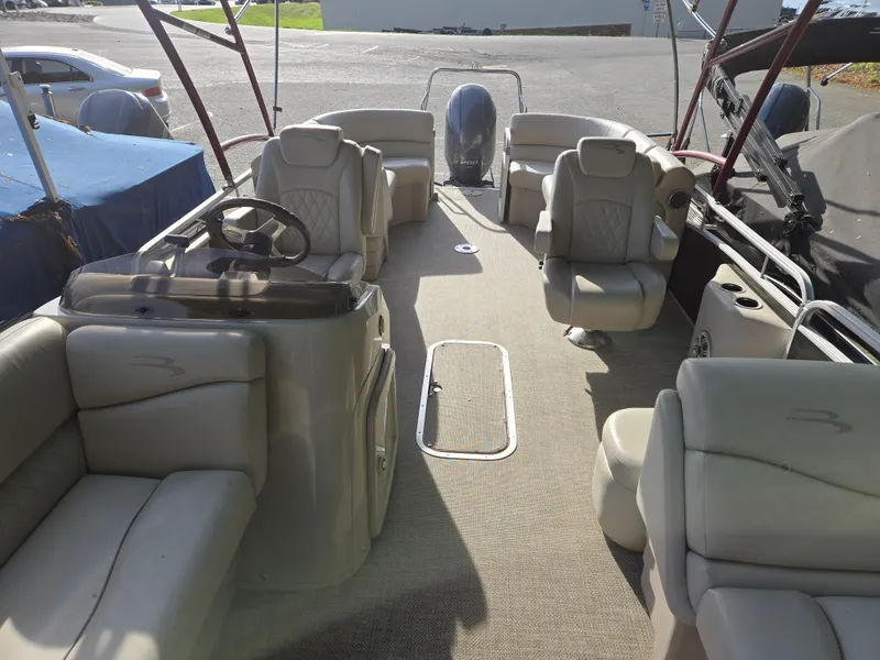 Slide: The Image of 2015 Bennington 24 SSRX30 pontoon boat interior with plush seating and steering console. - 24