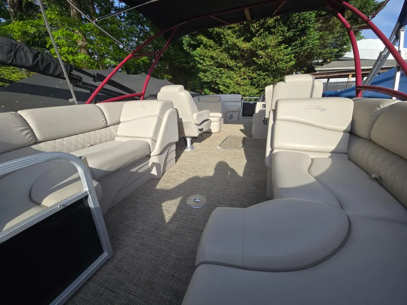 Slide: The Image of 2015 Bennington 24 SSRX30 pontoon boat with spacious beige seating and canopy. - 25