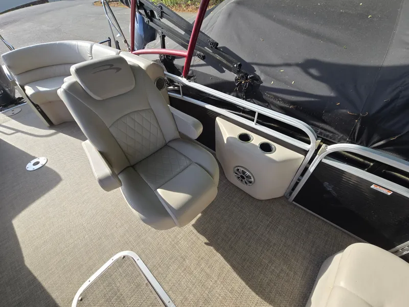 Slide: The Image of 2015 Bennington 24 SSRX30 boat interior with beige seating and cup holders. - 28