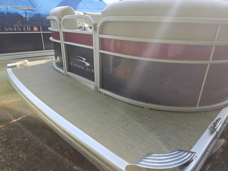 Slide: The Image of 2015 Bennington 24 SSRX30 pontoon boat with sunlit deck and seating area. - 3