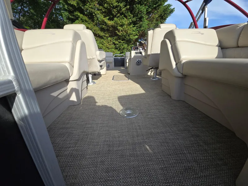Slide: The Image of 2015 Bennington 24 SSRX30 pontoon boat interior with beige seating and carpet flooring. - 32