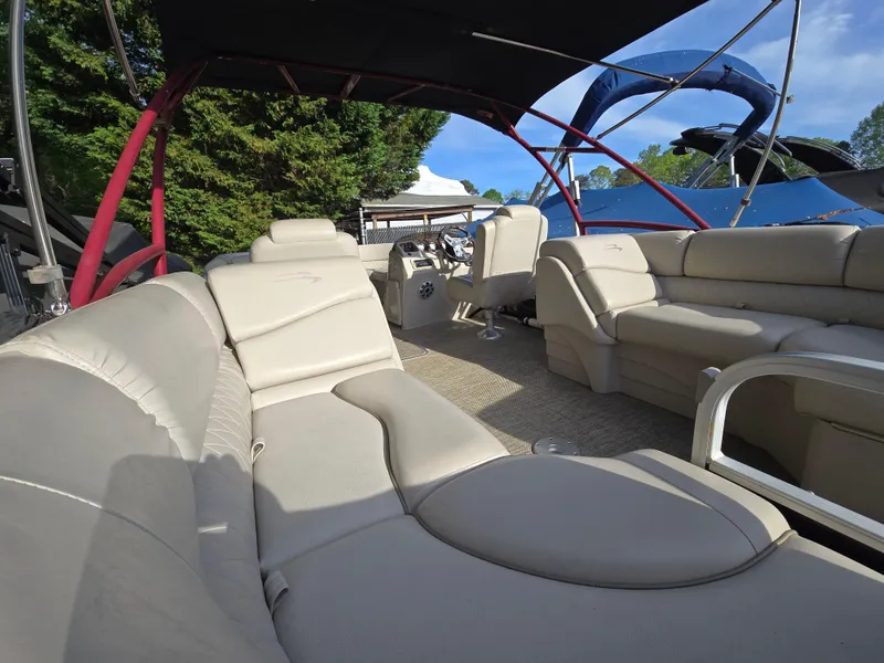 Slide: The Image of 2015 Bennington 24 SSRX30 pontoon boat with spacious beige seating and canopy. - 33