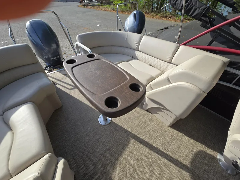 Slide: The Image of 2015 Bennington 24 SSRX30 boat interior with beige seating and a central table. - 37