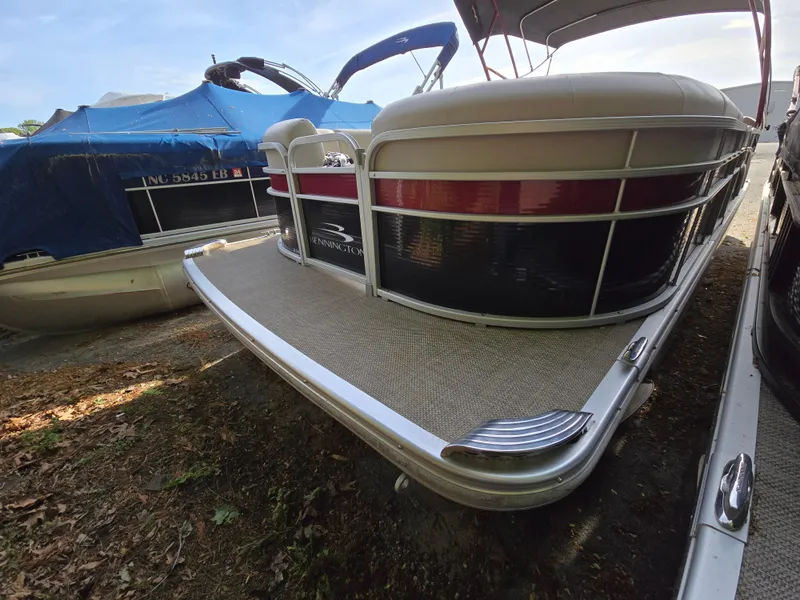 Slide: The Image of 2015 Bennington 24 SSRX30 pontoon boat docked on shore. - 4