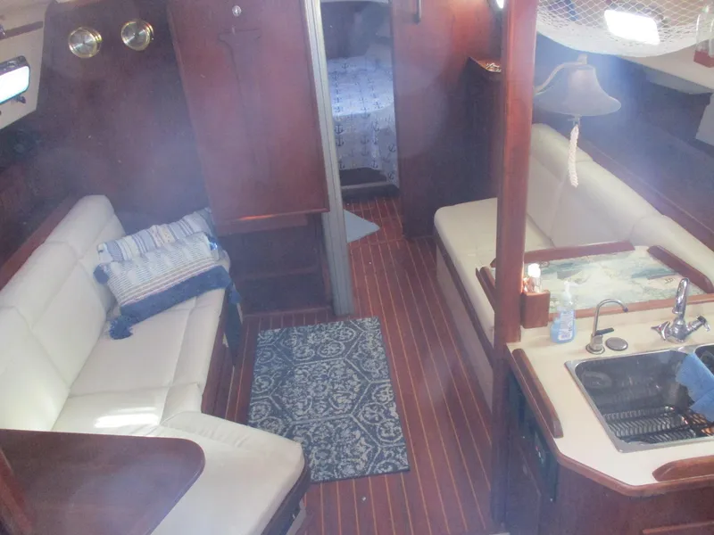 Slide: The Image of Interior of 1999 Island Packet 380 sailboat with cozy seating and wooden flooring. - 27