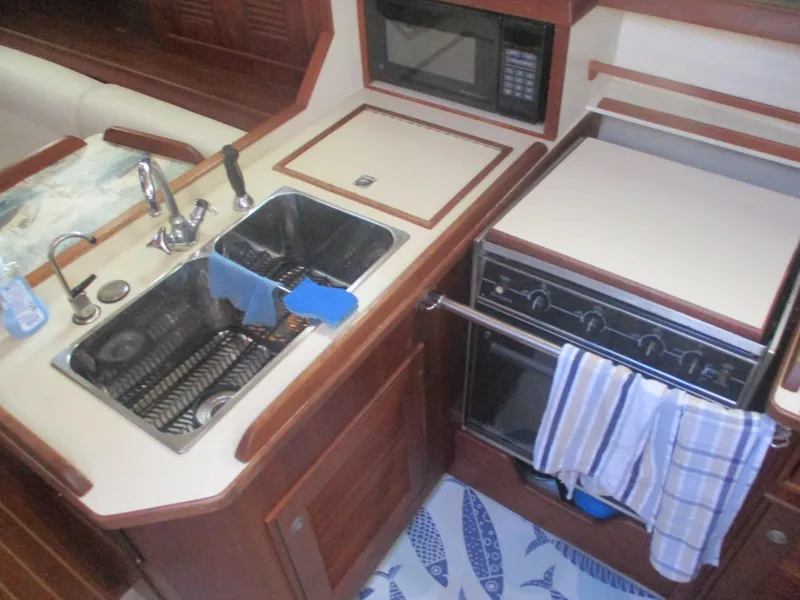 Slide: The Image of 1999 Island Packet 380 yacht kitchen with sink, stove, and microwave. - 28