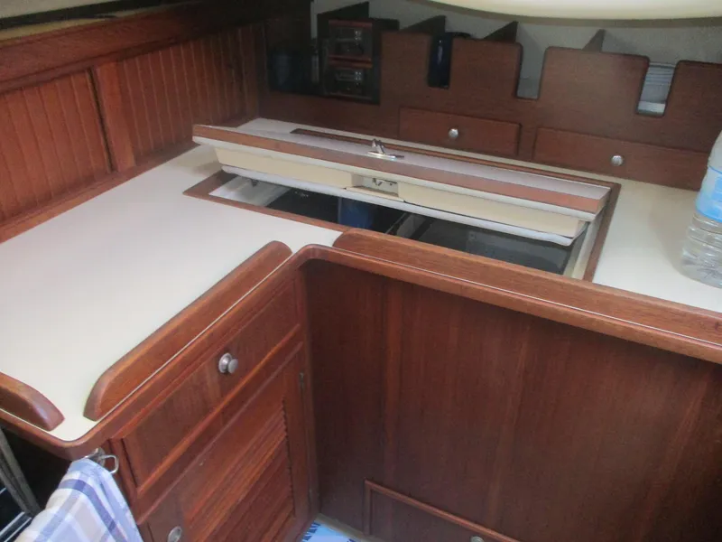 Slide: The Image of Interior of 1999 Island Packet 380 sailboat with wooden cabinetry and countertop. - 29