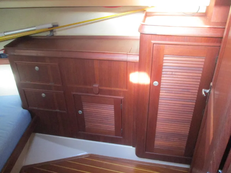 Slide: The Image of Interior of 1999 Island Packet 380 sailboat with wooden cabinetry and storage compartments. - 32