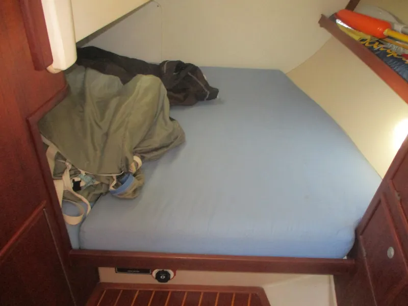 Slide: The Image of Cozy cabin bed in 1999 Island Packet 380 sailboat with blue bedding and wooden accents. - 33
