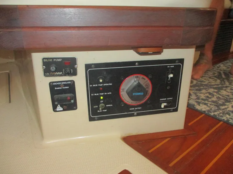 Slide: The Image of Control panel of a 1999 Island Packet 380 sailboat, featuring bilge pump and electrical switches. - 38