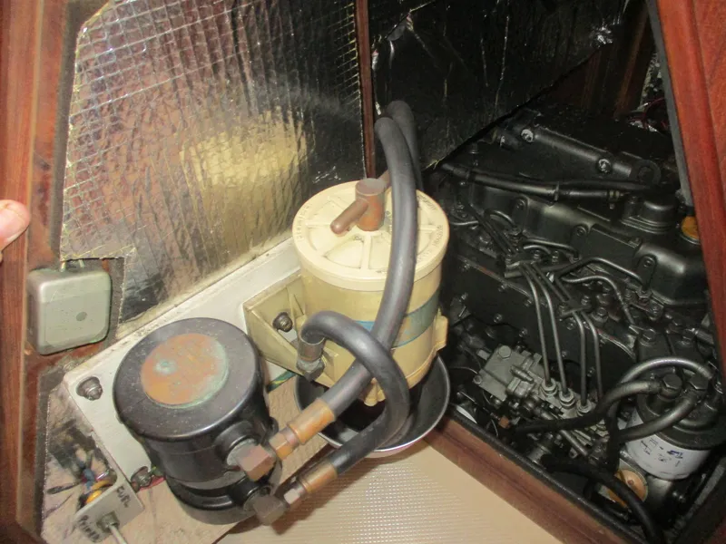 Slide: The Image of Engine compartment of a 1999 Island Packet 380 sailboat, showing fuel filter and engine components. - 39