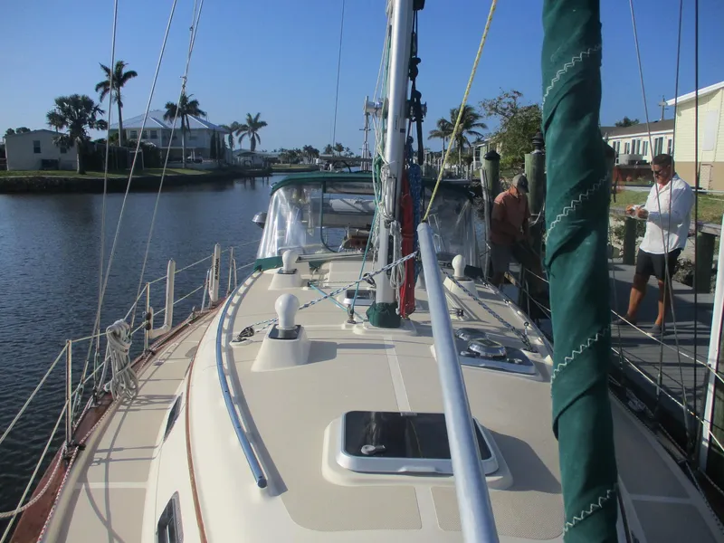 Slide: The Image of 1999 Island Packet 380 sailboat docked in a scenic canal with palm trees. - 7