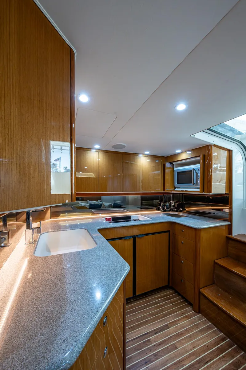 Slide: The Image of 2004 Viking Express Sport Fish yacht interior with modern kitchen and wooden cabinetry. - 10