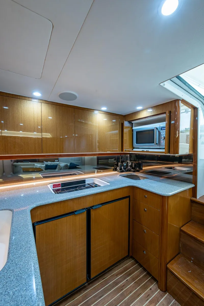 Slide: The Image of 2004 Viking Express Sport Fish yacht interior with modern kitchen and wooden cabinetry. - 11