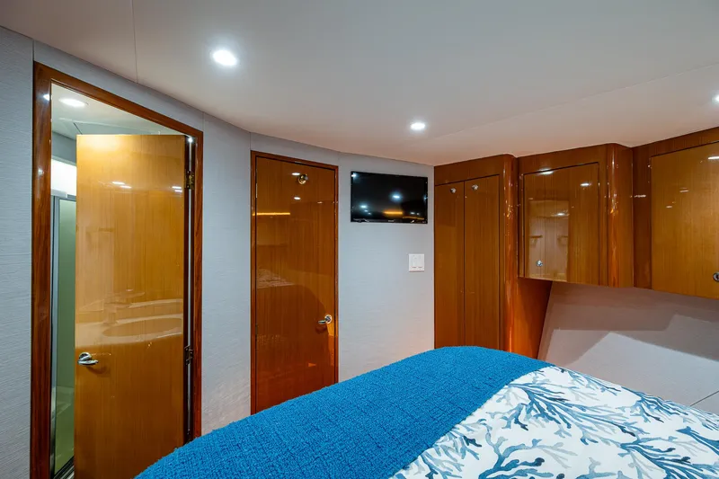 Slide: The Image of 2004 Viking Express Sport Fish cabin interior with wood paneling, bed, and TV. - 12