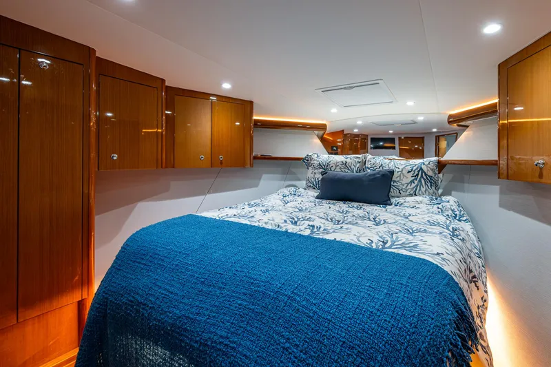 Slide: The Image of Luxurious cabin interior of 2004 Viking Express Sport Fish with cozy bedding and wooden cabinets. - 14