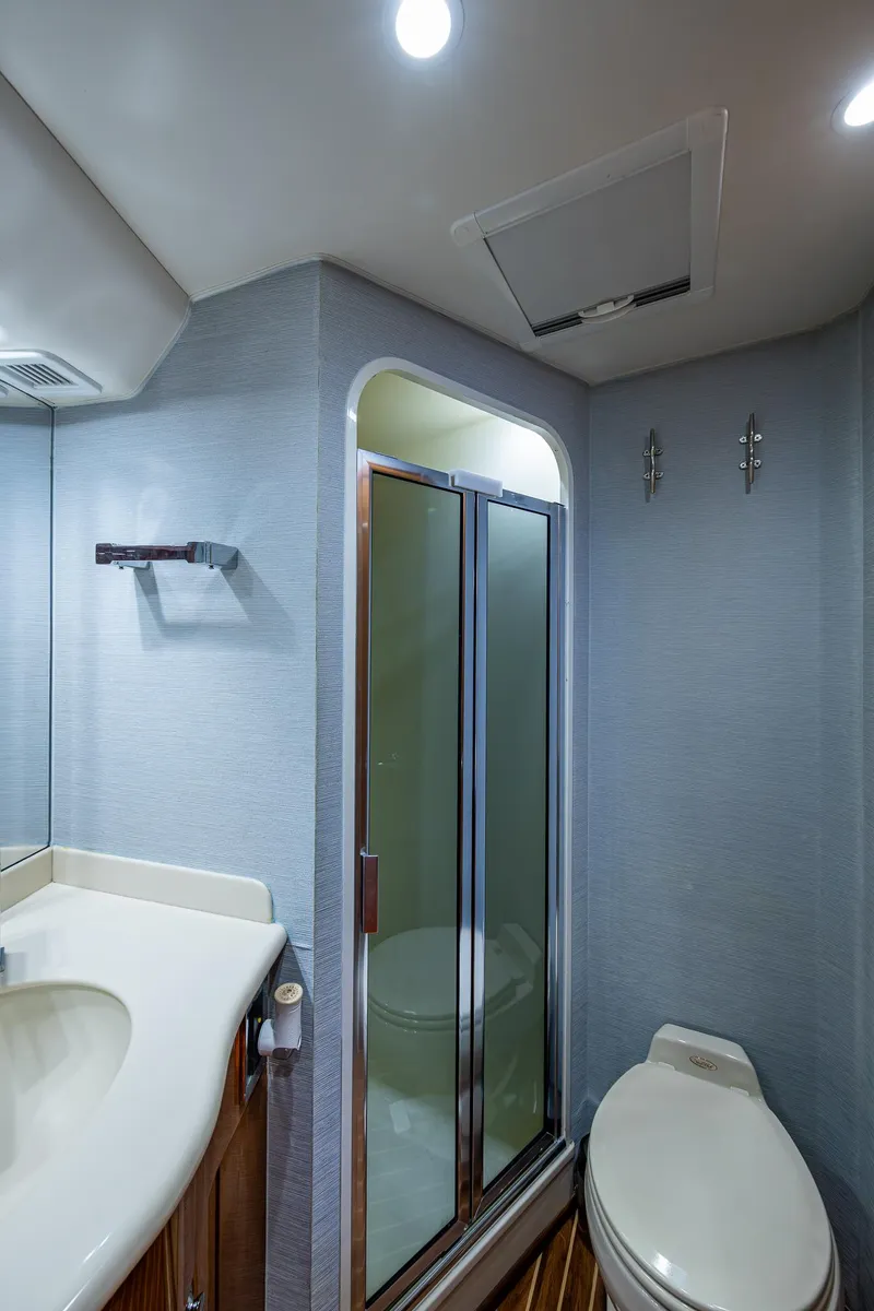 Slide: The Image of Bathroom interior of 2004 Viking Express Sport Fish boat, featuring shower and toilet. - 15