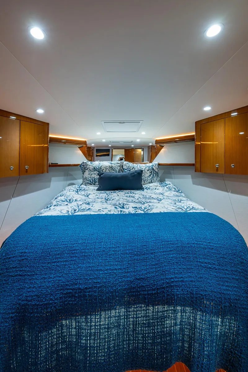 Slide: The Image of Luxurious cabin interior of 2004 Viking Express Sport Fish with cozy bedding and wooden cabinets. - 16
