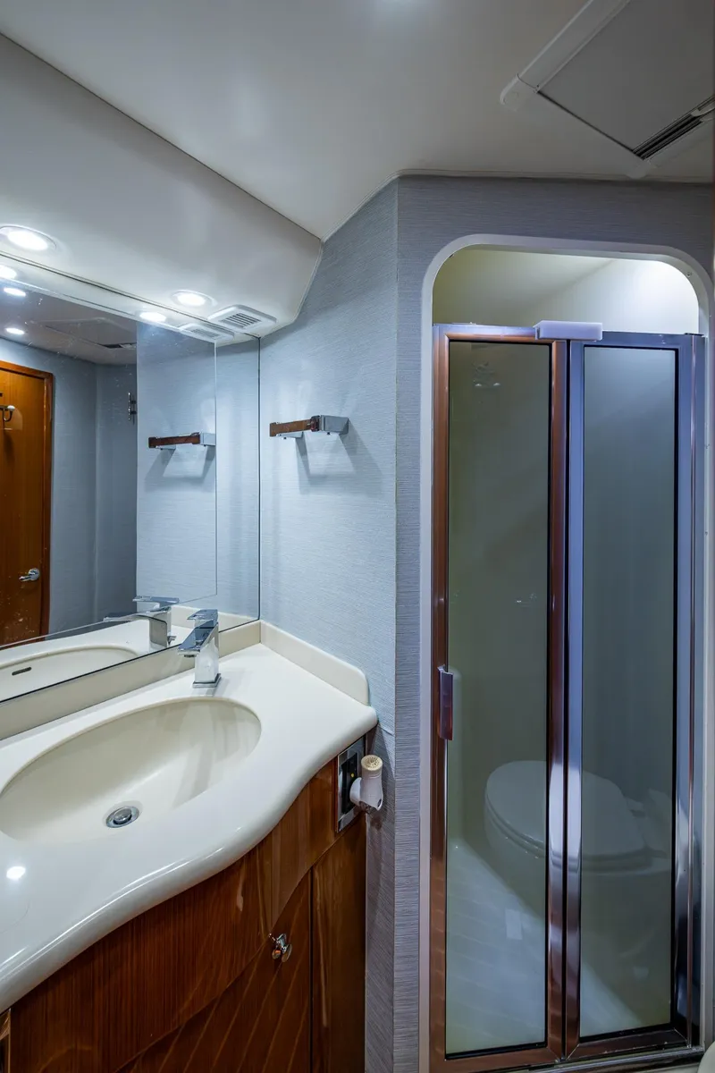 Slide: The Image of 2004 Viking Express Sport Fish bathroom with sink, mirror, and shower. - 17