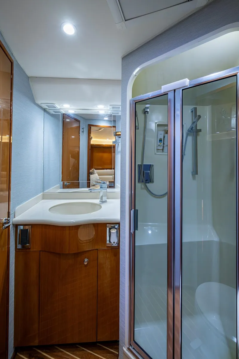 Slide: The Image of 2004 Viking Express Sport Fish bathroom with shower, sink, and wooden cabinetry. - 18