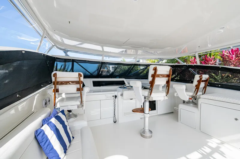 Slide: The Image of 2004 Viking Express Sport Fish yacht interior with helm chairs and striped cushions. - 27