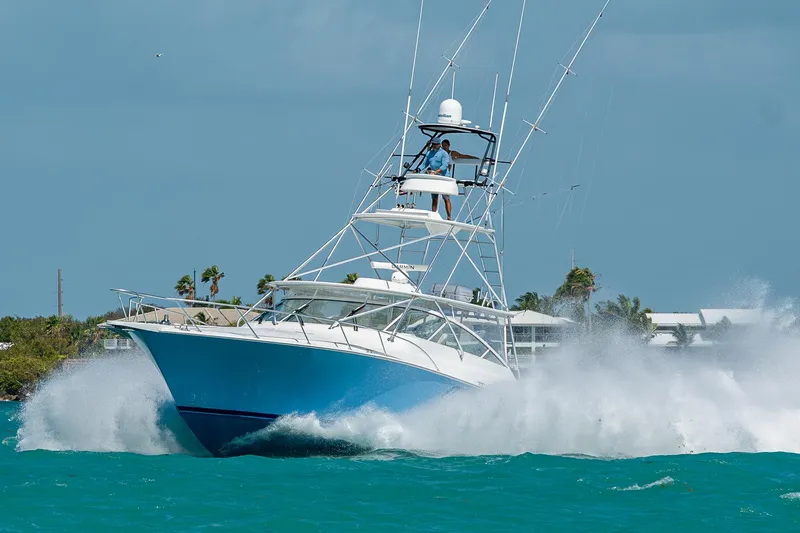 Slide: The Image of 2004 Viking Express Sport Fish boat cruising through turquoise waters. - 49