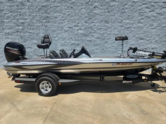 Slide: The Image of 2016 Triton 189 TRX bass boat with Mercury engine, parked on a trailer. - 1