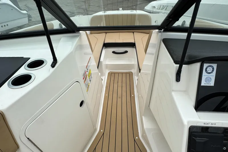 Slide: The Image of 2022 Sea Ray SPX 210 OB boat interior with tan seating and wood-style flooring. - 15
