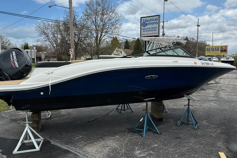Slide: The Image of 2022 Sea Ray SPX 210 OB boat displayed on stands in a parking lot. - 4