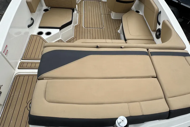 Slide: The Image of 2022 Sea Ray SPX 210 OB boat interior with tan and black seating, teak flooring. - 7