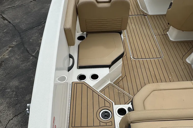 Slide: The Image of 2022 Sea Ray SPX 210 OB boat interior with tan seating and wood-style flooring. - 8