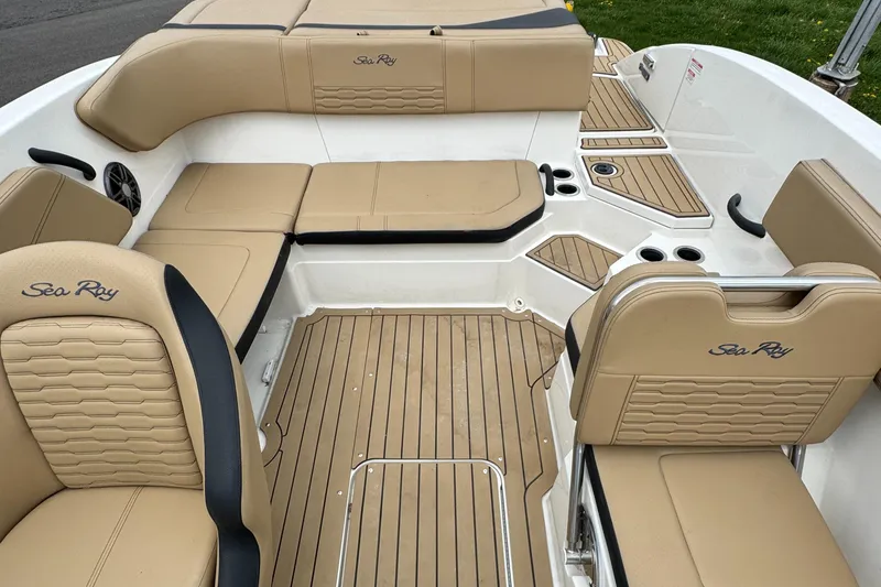 Slide: The Image of 2022 Sea Ray SPX 210 OB boat interior with tan seating and teak flooring. - 9